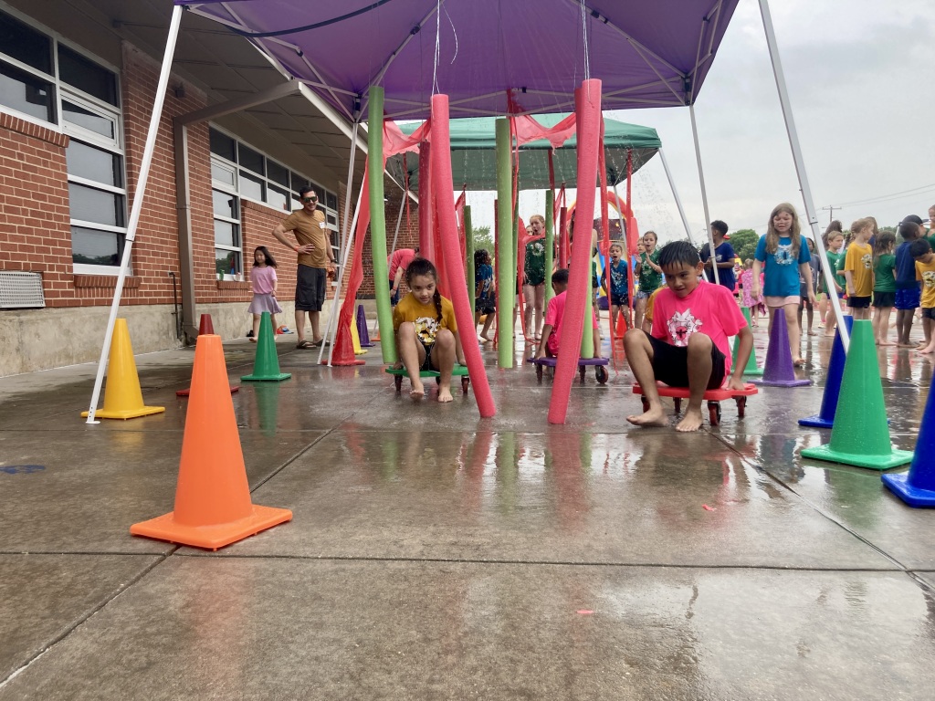 ACM students scoot their way through the water obstacle course!