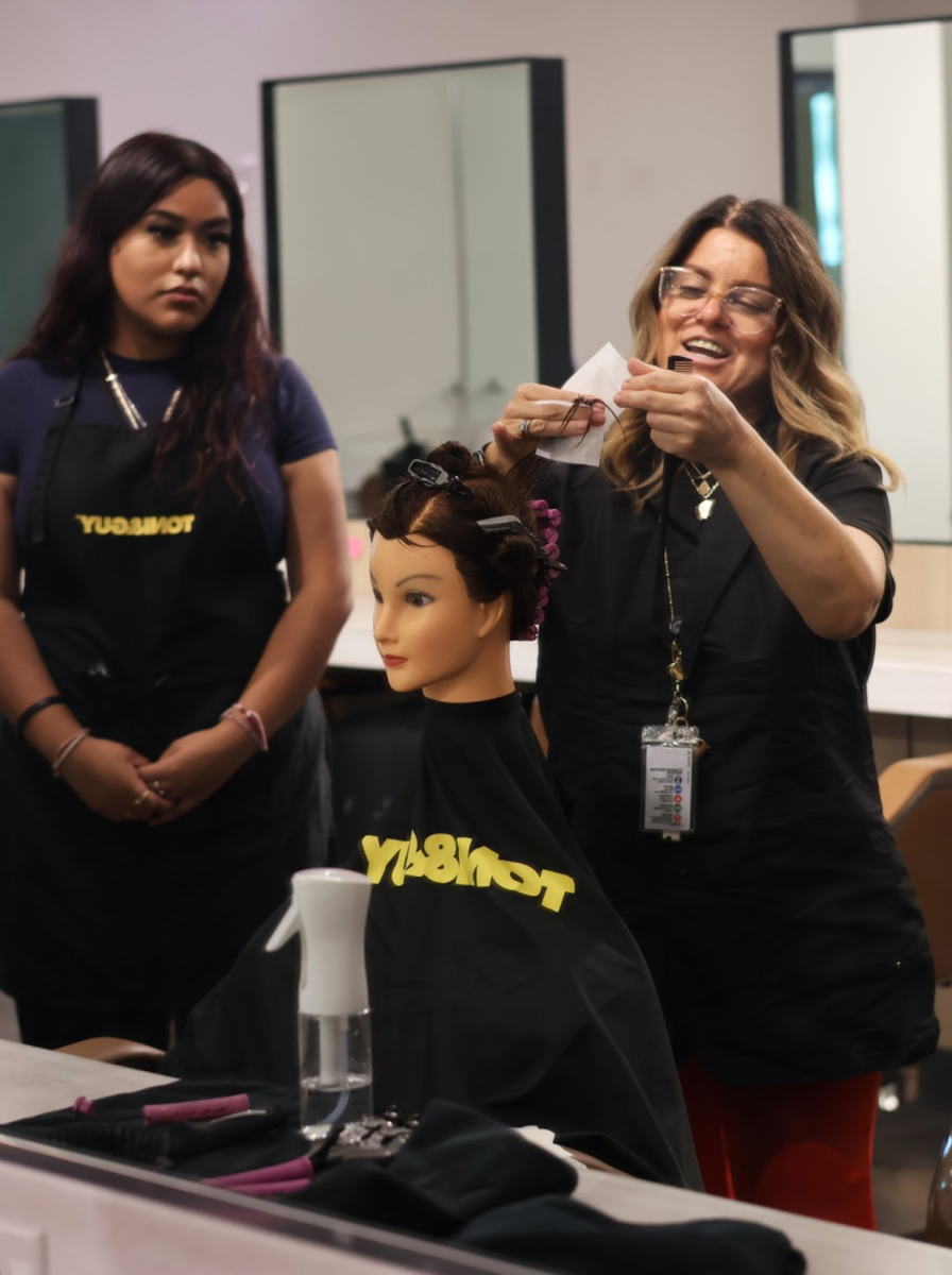 Cosmetology teacher demonstrates how to do perms.