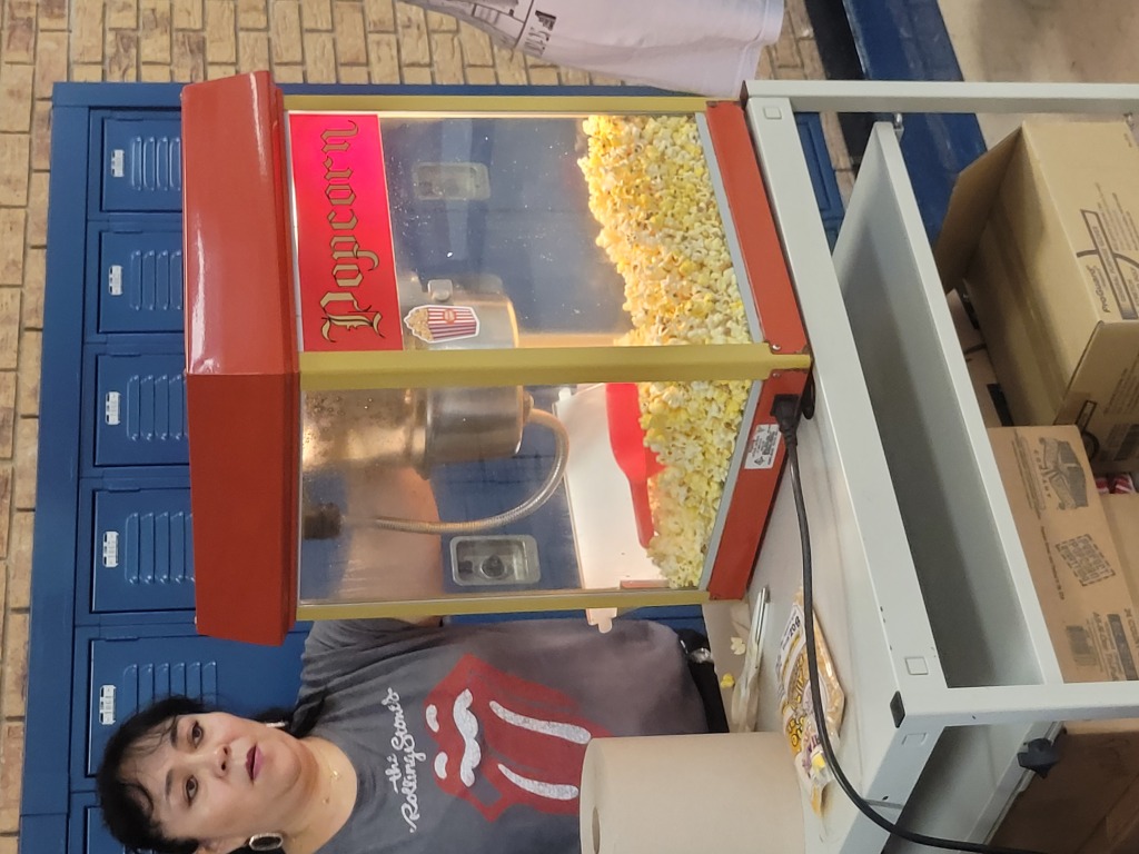 Mrs. Del Valle prepares bags of popcorn for students during lunch.