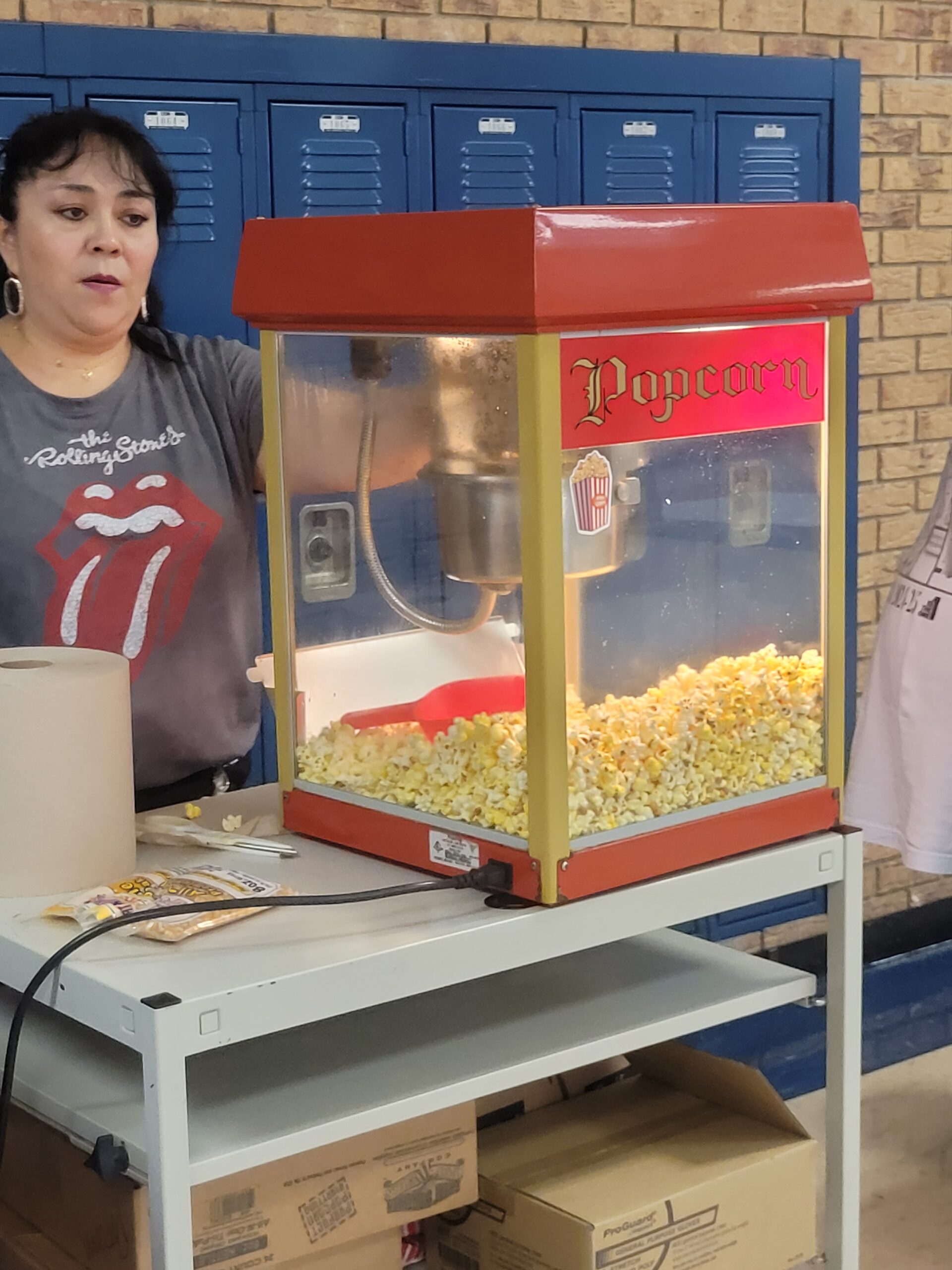 Mrs. Del Valle prepares bags of popcorn for students during lunch.