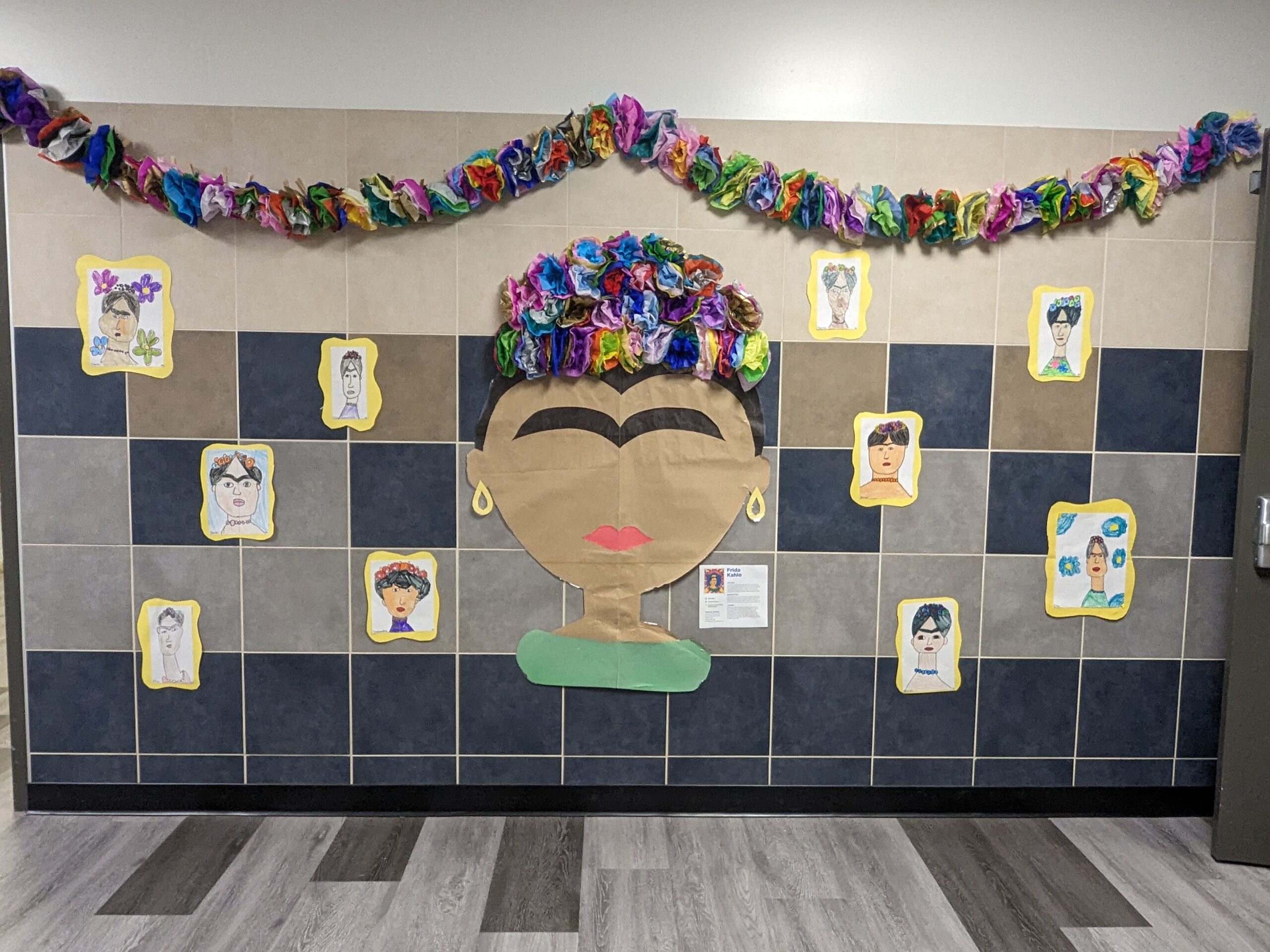 A large Frida Kahlo display with tissue paper flowers and student drawn portraits.