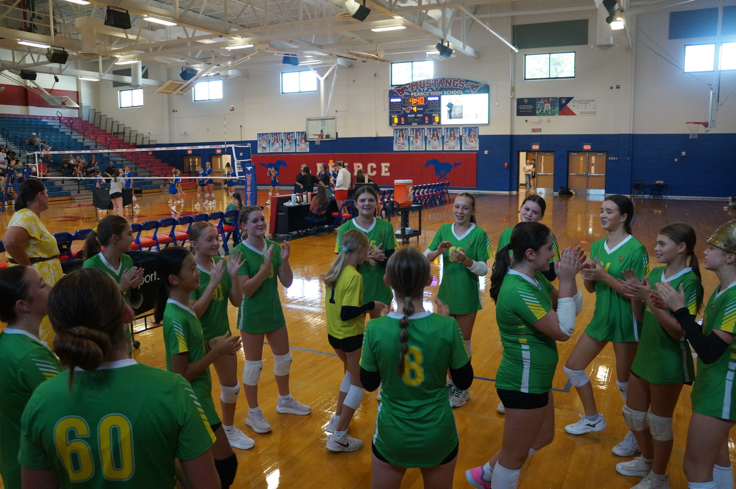 Volleyball players huddled together on court.