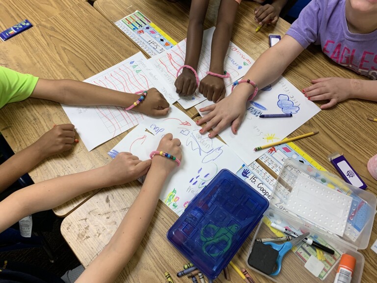 Student hands on a desk