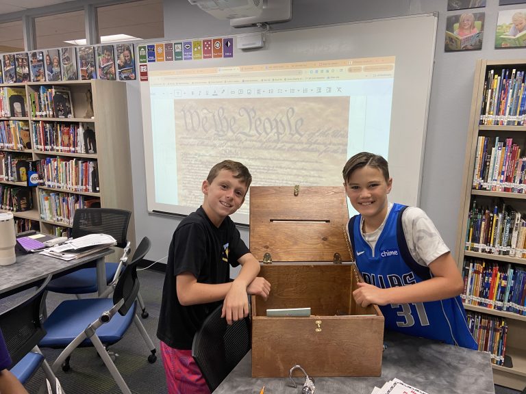 Two boys opening a lockbox for a Constitution Day activity.