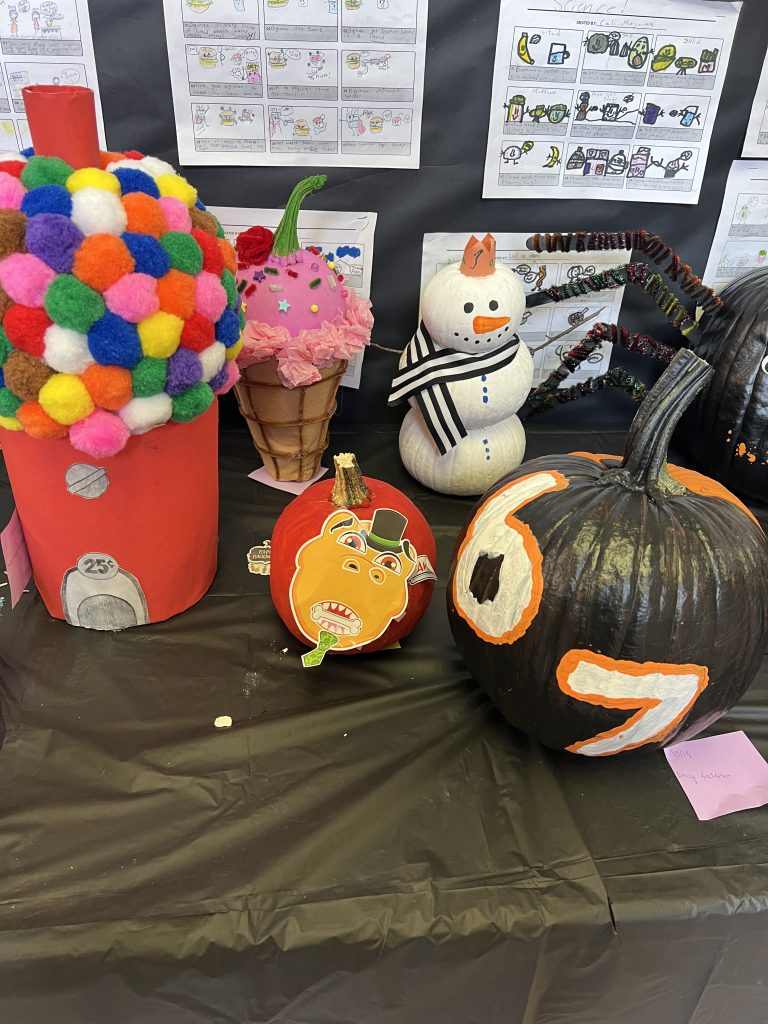 Students’ decorated pumpkins displayed on tables at Wallace Elementary’s annual pumpkin decorating contest, featuring creative and colorful designs.